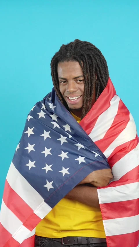 Latin man with dreadlocks wrapping with north america national flag 動画素材 252484323