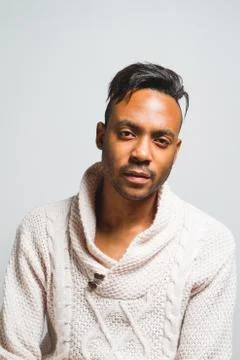 Latin man posing indoor over a grey wall. Stock Photos