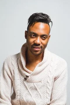 Latin man posing indoor over a grey wall. Stock Photos