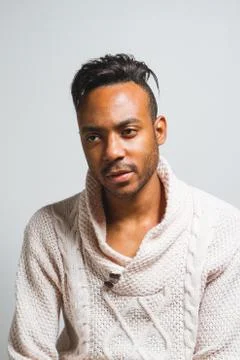 Latin man posing indoor over a grey wall. Stock Photos