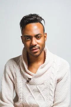 Latin man posing indoor over a grey wall. Stock Photos