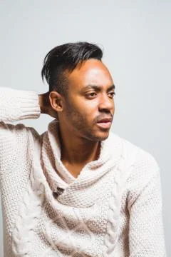 Latin man posing indoor over a grey wall. Stock Photos