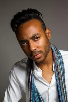 Latin man posing indoor over a grey wall. Stock Photos