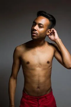 Latin man posing indoor over a grey wall. Stock Photos