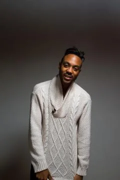 Latin man posing indoor over a grey wall. Stock Photos