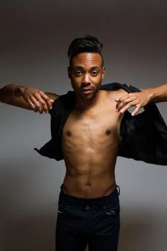 Latin man posing indoor over a grey wall. Stock Photos