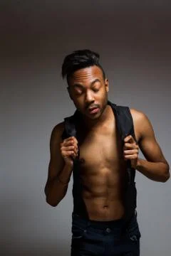 Latin man posing indoor over a grey wall. Stock Photos