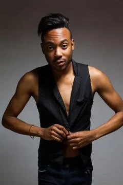 Latin man posing indoor over a grey wall. Stock Photos