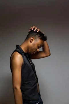 Latin man posing indoor over a grey wall. Stock Photos