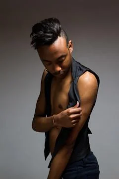 Latin man posing indoor over a grey wall. Stock Photos