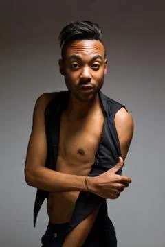 Latin man posing indoor over a grey wall. Stock Photos