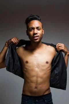 Latin man posing indoor over a grey wall. Stock Photos