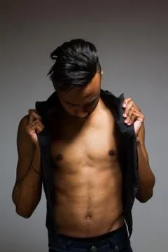 Latin man posing indoor over a grey wall. Stock Photos