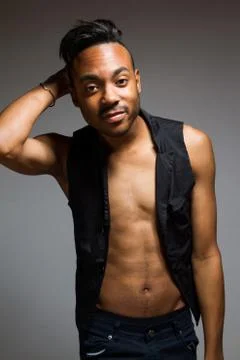 Latin man posing indoor over a grey wall. Stock Photos