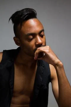 Latin man posing indoor over a grey wall. Stock Photos