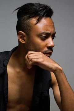 Latin man posing indoor over a grey wall Stock Photos