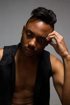 Latin man posing indoor over a grey wall. Stock Photos