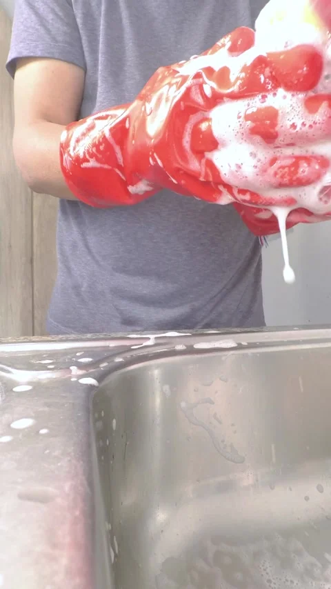 Latin man putting on red gloves to wash dishes Stock Footage 280367821