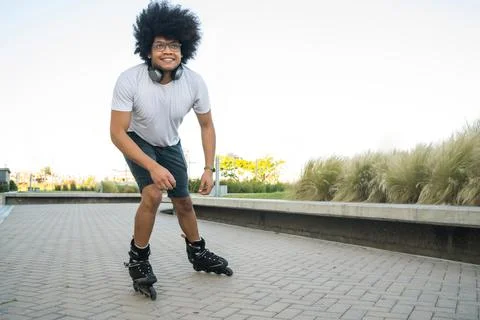 Latin man rollerskating outdoors. Stock Photos