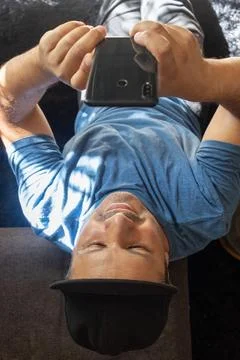 Latin man sitting down checking his cell phone, view from above Stock Photos