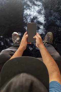 Latin man sitting down checking his cell phone, view from above Stock Photos
