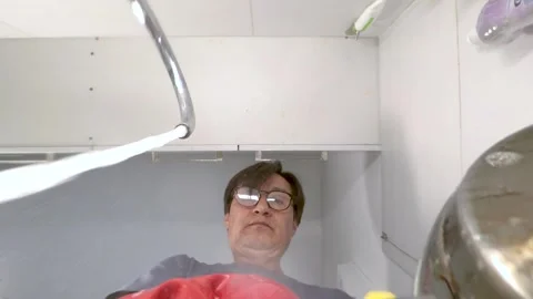 Latin man takes liquid soap on a sponge and washes dishes in the sink Stock Footage 280368073
