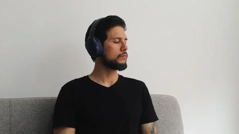 Latin man using a headset with the eyes closed into a reflexive attitude Vídeo Stock 340583493