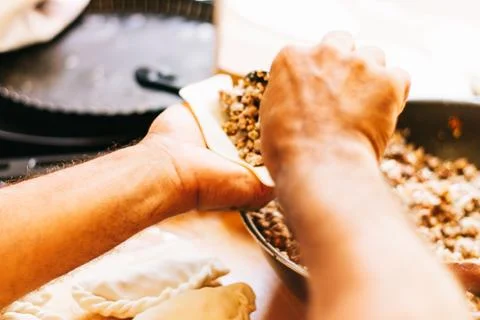 Latin man's hand preparing typical Argentine and South American pastries, "em Stock Photos