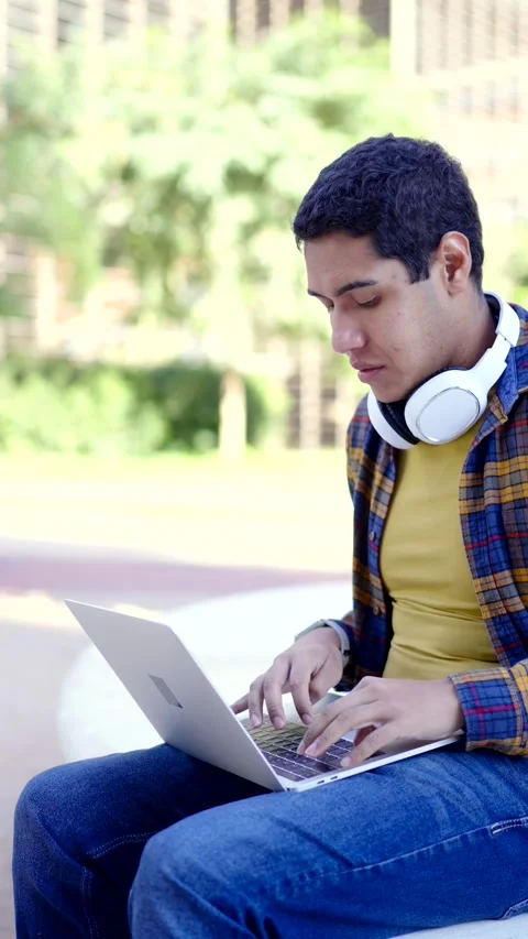 Latin young student using laptop sitting in the campus Stock Footage 258325425