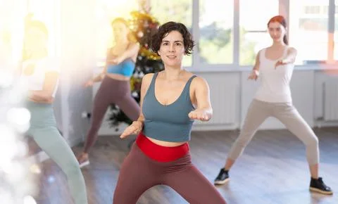 Latina enjoying active dance training in festively decorated studio Stock Photos