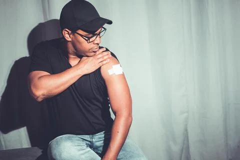 Latino brown man showing arm after covid vaccination Stock Photos