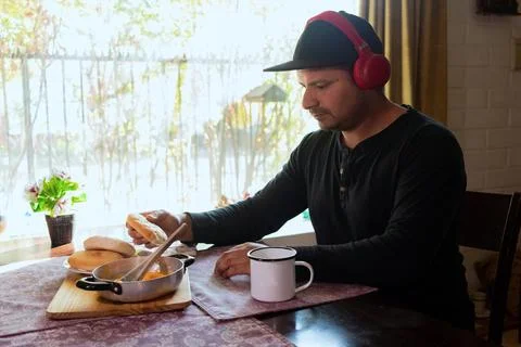 Latino man eats breakfast while listening to music Stock Photos