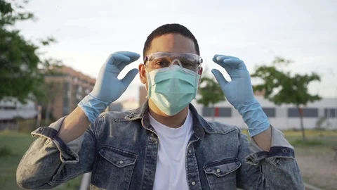 Latino Man Taking Mask Off in the End of Covid-19 Pandemic Outdoors. Stock Footage 129602421