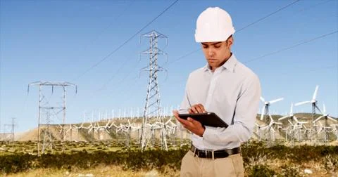 Latino millennial Engineer checking on wind turbines for renewable energy Stock Photos