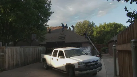 Latino workers remove shingle from a home in the early morning hours, 4K. Stock Footage 138813947
