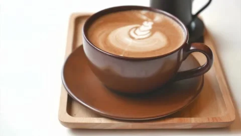 Latte art coffee in brown cup ready for drink on white table at cafe. Stock-Footage 334648706