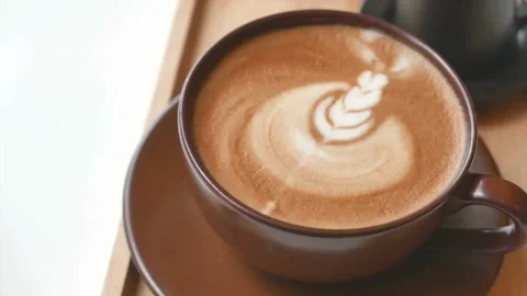 Latte art coffee in brown cup ready for drink on white table at cafe. Stock-Footage 334648761
