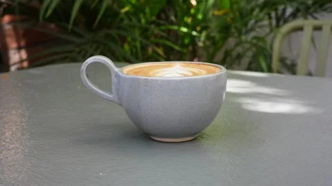Latte Art Coffee in Ceramic Mug With Green Plants Background Stock Footage 341827078