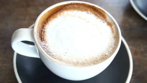 Latte art coffee ready for drink on table, overhead shot. Vídeo Stock 334648844