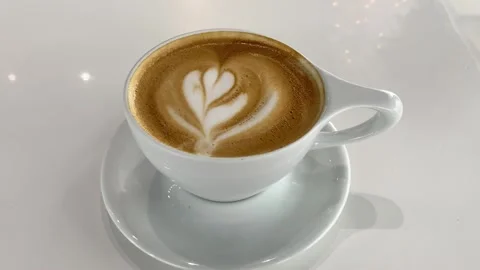 Latte Art Coffee on White Table in Modern Cafe with Christmas Tree, 4K Stock Footage 323568618