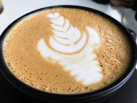 Latte art creating a beautiful leaf design in cusco coffee shop Stock Photos