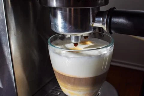 Latte being prepared in espresso machine, close up coffee making process Stock Photos