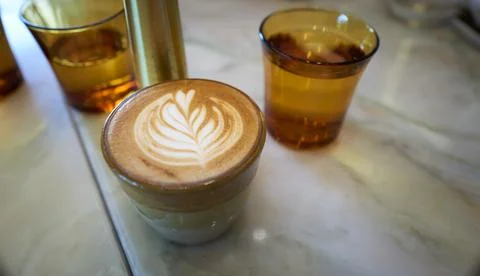 Latte in a cup on marble table Stock Photos