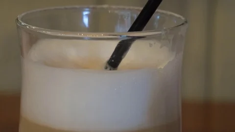 Latte drinking  with tube process. Foam level in glass is decreasing 库存影片 80997779