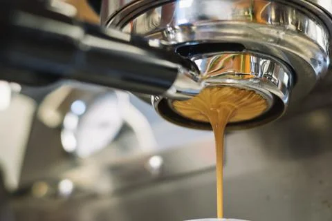 Latte dripping from a coffee machine Stock Photos