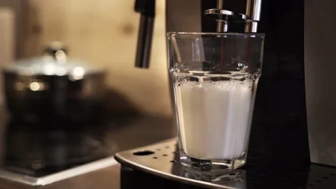 A latte macchiato gets prepared in the kitchen with blurry background Stock Footage 141192489