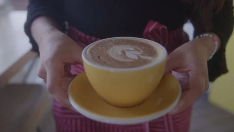 Latte with Pattern in Foam in Cup on Saucer Being Carried by Coffee Shop Owner Stock Footage 208801026