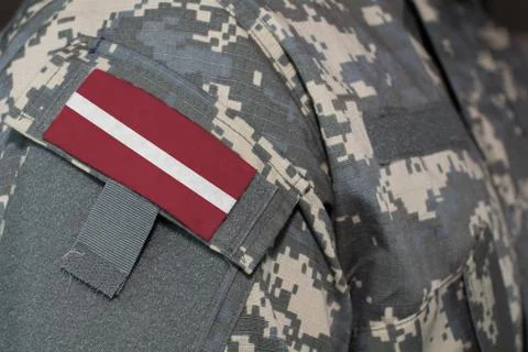 Latvia army uniform patch flag on soldiers arm. Military Concept Stock Illustration