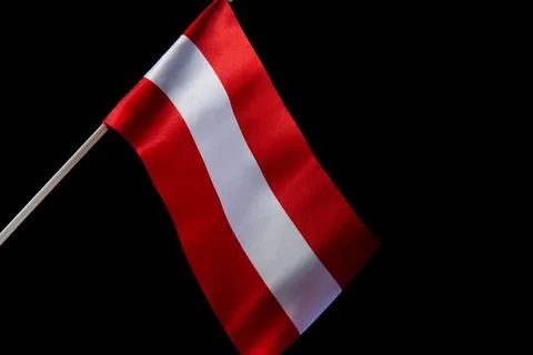 The Latvian flag on a black background is developing and flying in the wind Stockfoto's