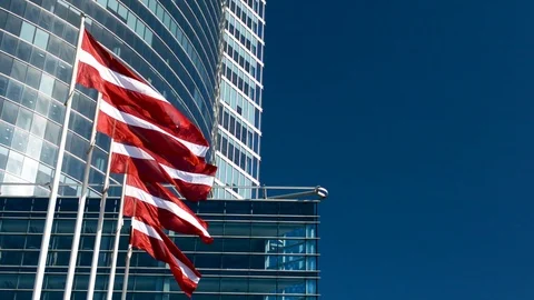 Latvian flag in front of an office skyscraper building on a sunny summer day 動画素材 89542092
